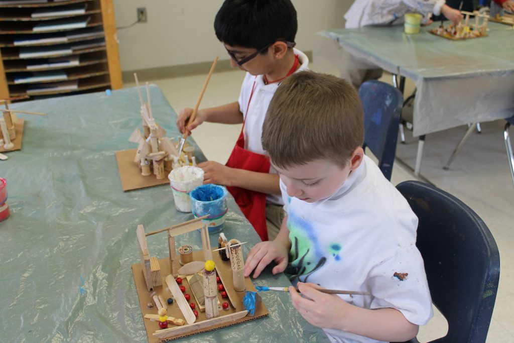 Elementary students painting their sculptures