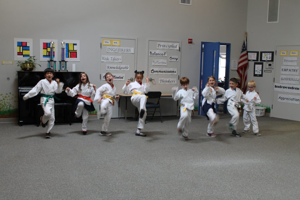 Elementary students practicing jump kicks for their karate belt tests