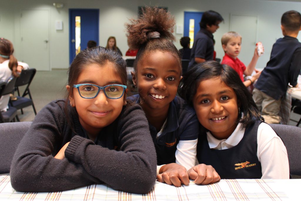 Three elementary girls smiling at the camera