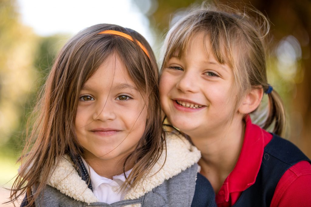 Two elementary school girls smiling at the camera