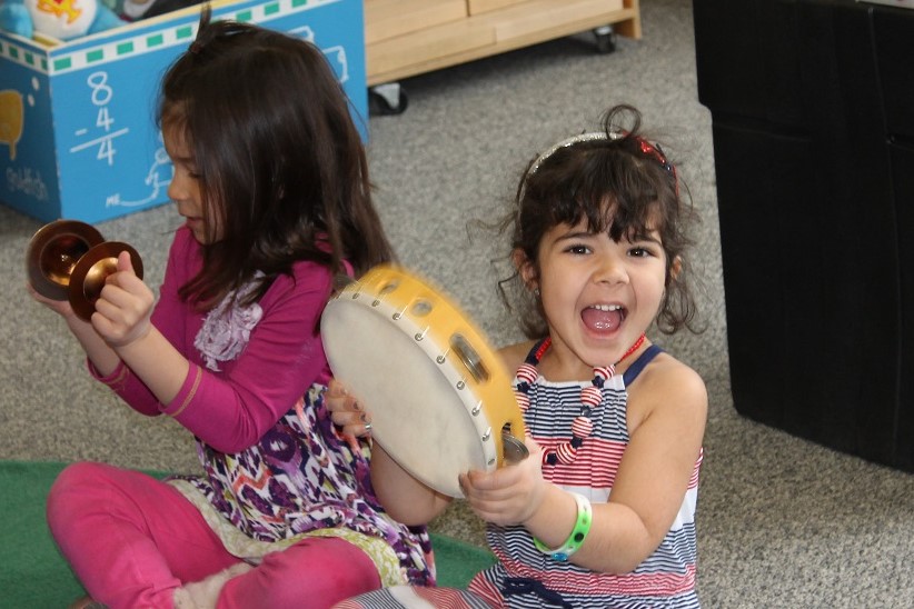 Preschool student playing tambourine